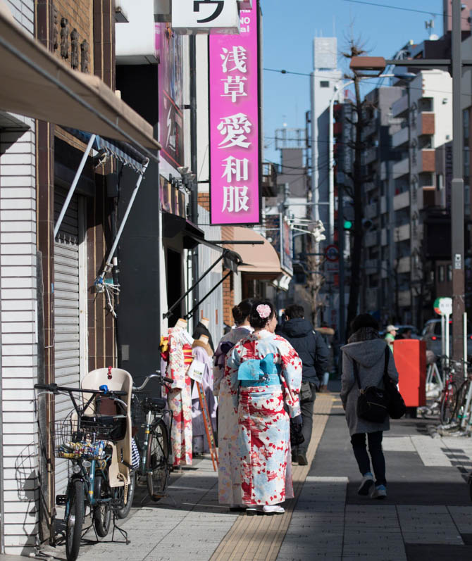 Japanese urban street scene with women dressed in Kimonos with backs to camera, Asakusa, Japan