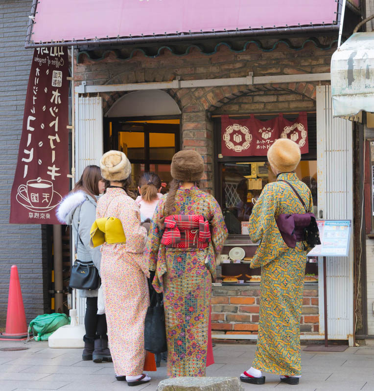 Group of young Japanese women dressed in Kimono, window shopping. Asakusa, Japan, 2018