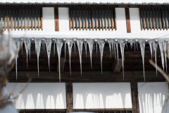Alpine house with long icicles hanging from roof. Nagano, Japan