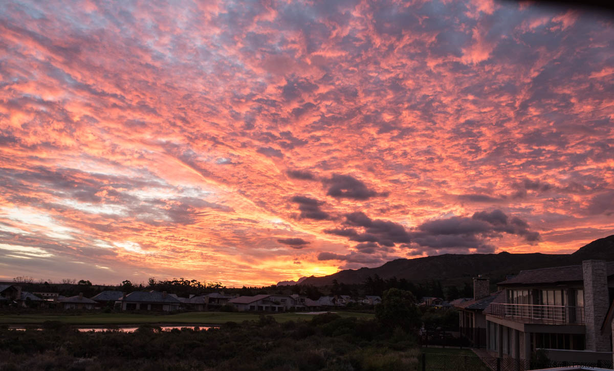 Stunning sunset behind cloudy sky with sunset reflecting on water inforefront